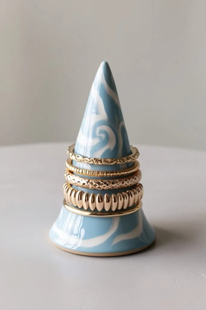 DIY pastel blue and white ring cone holding gold rings