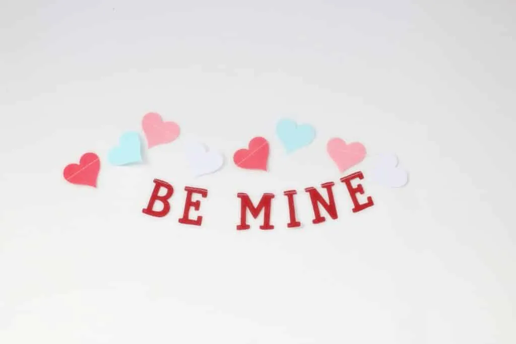 Charming arrangement of colorful hearts and 'Be Mine' text, perfect for Valentine's Day.